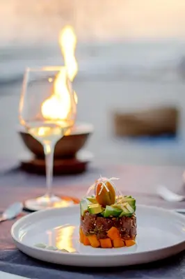 a plate of food on a table with a glass of wine at Luxury Beachfront Villa with private pool at Nantipa in Santa Teresa Beach