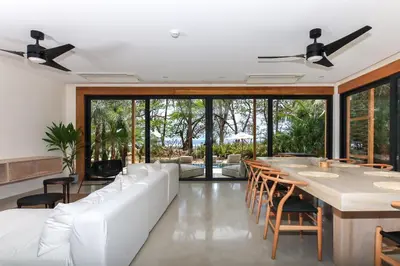 a living room with white furniture and a long table at Luxury Beachfront Villa with private pool at Nantipa in Santa Teresa Beach