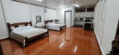 a large room with two beds and a kitchen at Sleep&Go! Cabina Cuadruple en Siquirres Centro - and rafting tour! in Siquirres