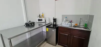 a small kitchen with a sink and a microwave at Sleep&Go! Cabina Cuadruple en Siquirres Centro - and rafting tour! in Siquirres