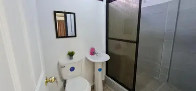 a bathroom with a toilet and a sink and a shower at Sleep&Go! Cabina Cuadruple en Siquirres Centro - and rafting tour! in Siquirres