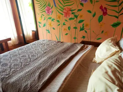 a bedroom with a bed with a floral wall at Casa de Montaña Tica Linda in Monteverde Costa Rica