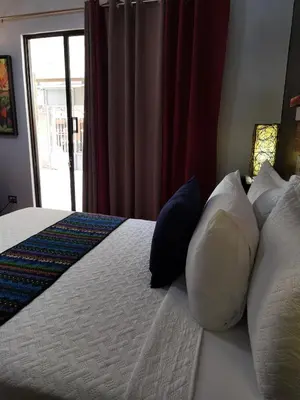 a bedroom with a bed with pillows and a window at Sunrise House in Quepos