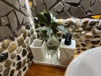 a vase with a plant in it on a shelf at Sunrise House in Quepos