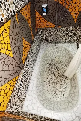 a bathroom with a mosaic tile wall with a tub at Sunrise House in Quepos