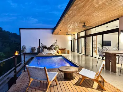 a pool on the roof of a house with chairs and a table at Seataya Villas in Santa Teresa Beach