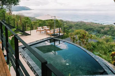 a swimming pool with a view of the ocean at Seataya Villas in Santa Teresa Beach