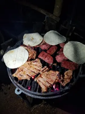 a grill with meat and other food on it at Escapadita al Bosque in San Isidro