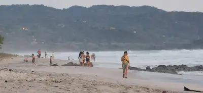a group of people walking on the beach at Villa Carlotta in Respingue