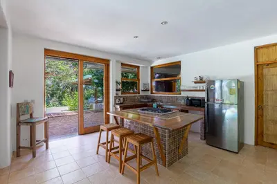 a kitchen with a counter and a refrigerator at Villa Carlotta in Respingue