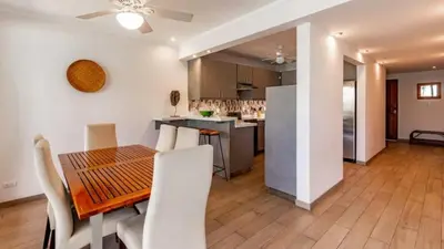 a dining room and kitchen with a table and chairs at Elegant Condo with Brand-New Fixtures, Shaded Tropical Terrace, and Secluded Beach Access in Playa Flamingo
