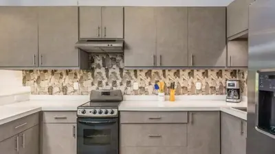 a kitchen with a stove top oven next to cabinets at Elegant Condo with Brand-New Fixtures, Shaded Tropical Terrace, and Secluded Beach Access in Playa Flamingo