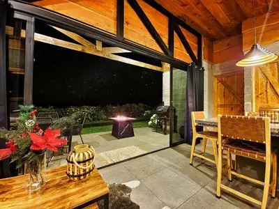 a screened in patio with a table and a dining room at Espectacular Cabaña Moderna de Montaña + Bosque Nuboso +Wifi in Zarcero