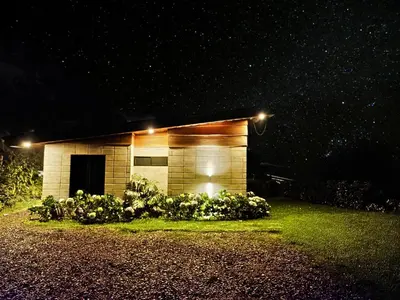 a small building with lights on it at night at Espectacular Cabaña Moderna de Montaña + Bosque Nuboso +Wifi in Zarcero