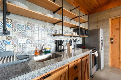 a kitchen with a sink and a refrigerator at Espectacular Cabaña Moderna de Montaña + Bosque Nuboso +Wifi in Zarcero