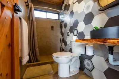 a bathroom with a toilet and a shower at Espectacular Cabaña Moderna de Montaña + Bosque Nuboso +Wifi in Zarcero