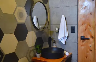 a bathroom with a sink and a mirror at Espectacular Cabaña Moderna de Montaña + Bosque Nuboso +Wifi in Zarcero