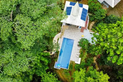 an overhead view of a house with a swimming pool and trees at Lost Pools Bungalow in Uvita