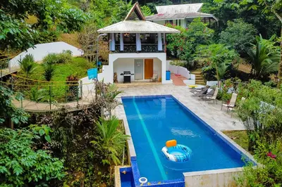 an aerial view of a swimming pool in front of a house at Lost Pools Bungalow in Uvita