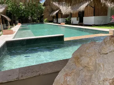 a large swimming pool with a rock in front of it at LA QUEBRADA ECO LODGE Hotel Boutique in Potrero