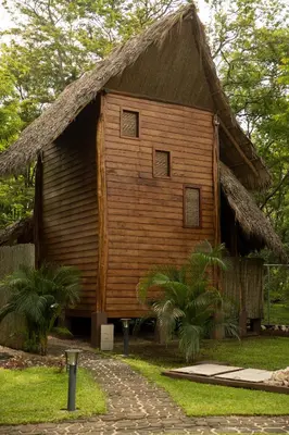 a small wooden house with a thatched roof at LA QUEBRADA ECO LODGE Hotel Boutique in Potrero