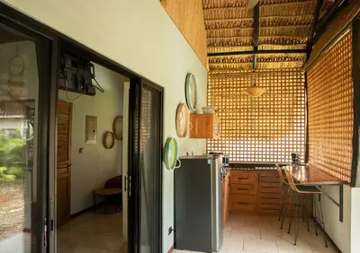 a kitchen with a refrigerator and a table in it at LA QUEBRADA ECO LODGE Hotel Boutique in Potrero