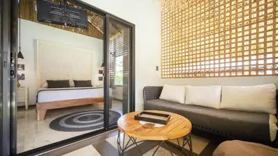 a living room with a couch and a bed at LA QUEBRADA ECO LODGE Hotel Boutique in Potrero