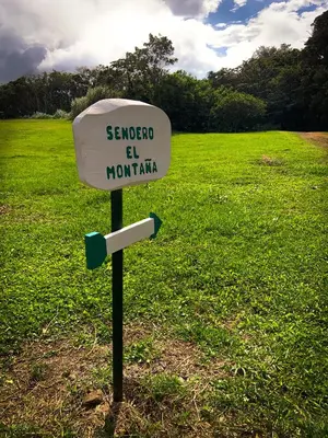 a sign in the middle of a grass field at Hotel Montaña Monteverde in Monteverde Costa Rica