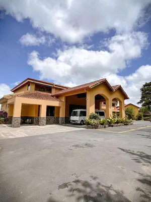 a building with a van parked in a parking lot at Hotel Montaña Monteverde in Monteverde Costa Rica