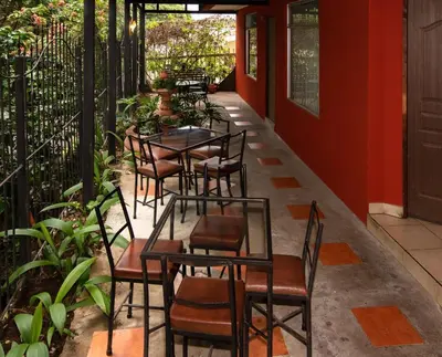 a row of tables and chairs on a patio at Melrost Airport Bed & Breakfast in Alajuela City