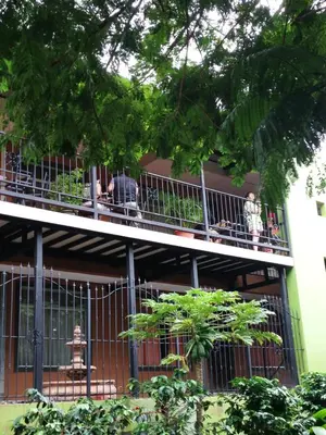people standing on the balcony of a building at Melrost Airport Bed & Breakfast in Alajuela City