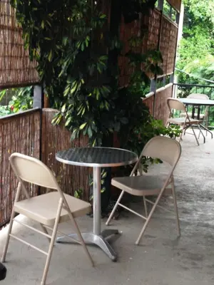 two chairs and a table and two tables and chairs at Melrost Airport Bed & Breakfast in Alajuela City