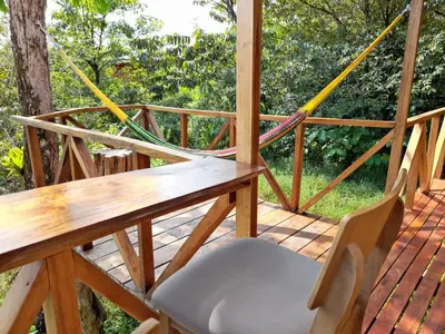 a wooden deck with a table and chairs on it at Onca Tours & Treehouses in San Rafael