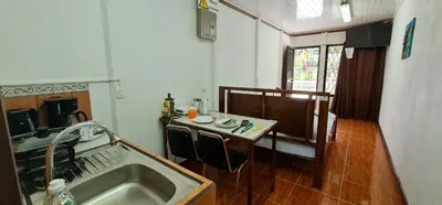 a kitchen with a sink and a small table with chairs at Sleep&Go! Cabinas en Siquirres Centro - Rafting tour - Tarifa corporativa Disponible in Siquirres