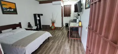 a bedroom with a bed and a flat screen tv at Sleep&Go! Cabinas en Siquirres Centro - Rafting tour - Tarifa corporativa Disponible in Siquirres