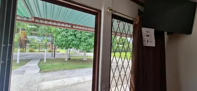 an open door with a view of a yard at Sleep&Go! Cabinas en Siquirres Centro - Rafting tour - Tarifa corporativa Disponible in Siquirres
