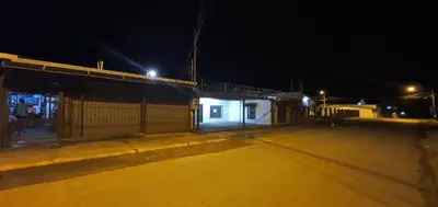 an empty street at night with a fence and a building at Sleep&Go! Cabinas en Siquirres Centro - Rafting tour - Tarifa corporativa Disponible in Siquirres
