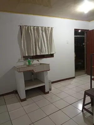 a room with a table and a curtain on a wall at Departamentos Patricia in Alajuela City
