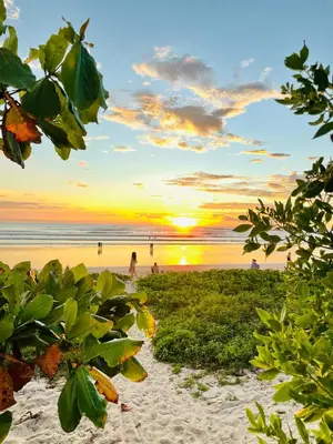 a sunset on a beach with people on the beach at Norte Nosara - Steps to Playa Guiones in Nosara
