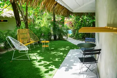 a patio with chairs and a table in a yard at Norte Nosara - Steps to Playa Guiones in Nosara