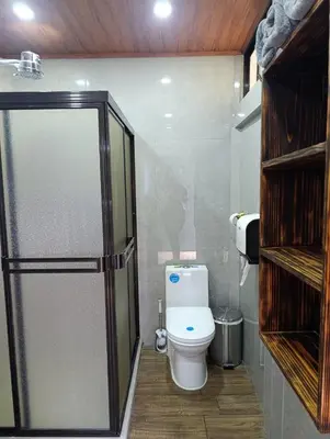 a bathroom with a toilet and a glass shower door at Villas Paradise Arenal Volcano Lake View in El Castillo de La Fortuna