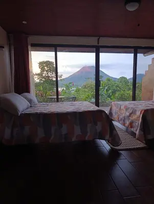 a bedroom with a bed with a view of a mountain at Villas Paradise Arenal Volcano Lake View in El Castillo de La Fortuna