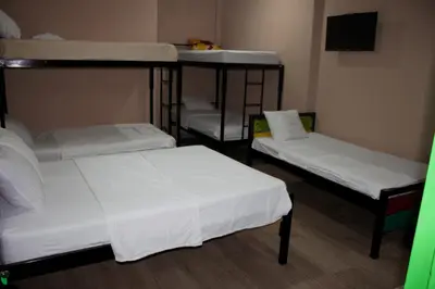 a room with three bunk beds with white sheets at Hotel La Castella in San José