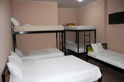 three bunk beds in a room with white sheets at Hotel La Castella in San José