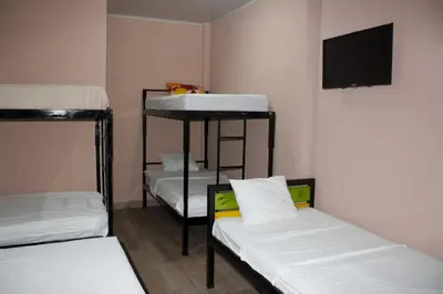 a room with three bunk beds and a flat screen tv at Hotel La Castella in San José