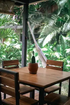a wooden table with two chairs and a hammock at El Hábita CASA MAR in Santa Teresa Beach
