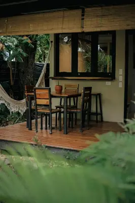 a wooden deck with a table and chairs on it at El Hábita CASA MAR in Santa Teresa Beach