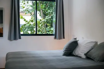 a bed with two pillows in a room with a window at El Hábita CASA MAR in Santa Teresa Beach