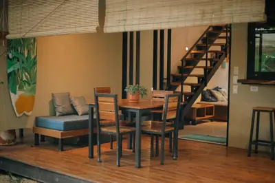 a dining room with a table and chairs and a staircase at El Hábita CASA SELVA in Santa Teresa Beach