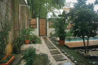 a garden with potted plants and a swimming pool at El Hábita CASA SELVA in Santa Teresa Beach